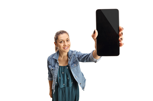 Young woman holding mobile phone screen in front of camera isolated on white background