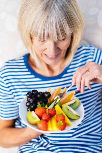 istock Attractive senior woman with fruit lunch 1297738998