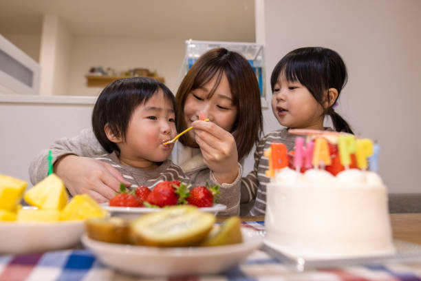 istock Young mother feeding her baby boy at his first birthday 1297739191