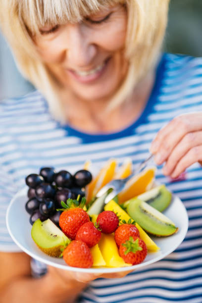 istock Attractive senior woman with fruit lunch 1297740006