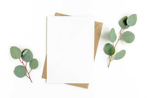 istock Mockup invitation, blank greeting card and green leaves eucalyptus. Flat lay, top view 1297740087