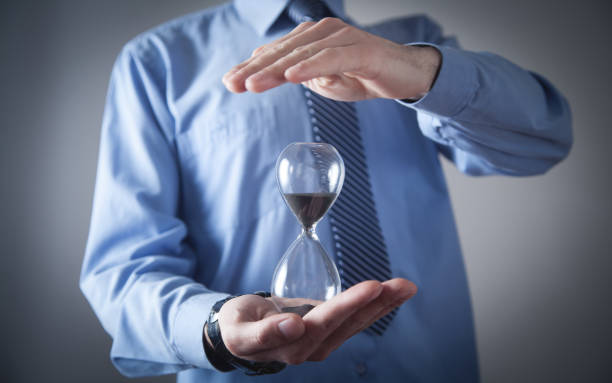 istock Businessman holding hourglass. Deadline concept 1297740228