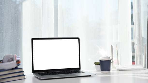 istock Computer laptop with blank screen putting in front of high speed wireless internet router on white table. 1297741064