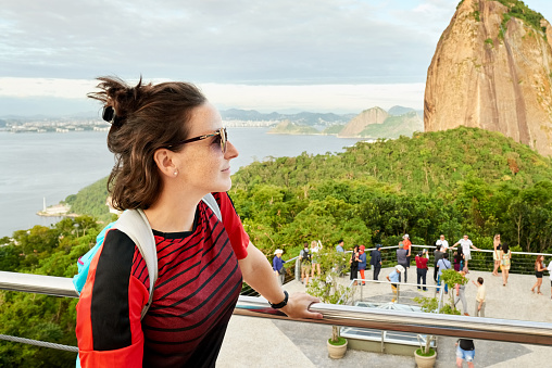 Woman on solo vacation in Rio De Janeiro, standing in front of Sugarloaf mountain