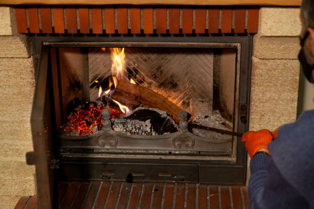istock Masked man straightens log in burning fireplace 1297742272