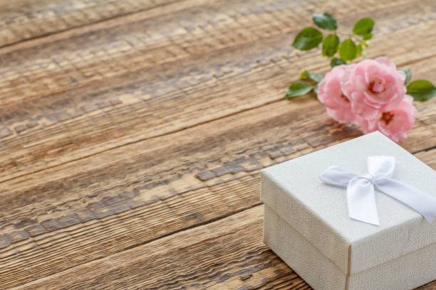 istock Gift box on wooden boards with rose flowers 1297742551