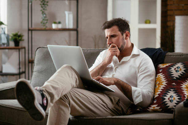 istock Businessman sitting on sofa having video call 1297742622