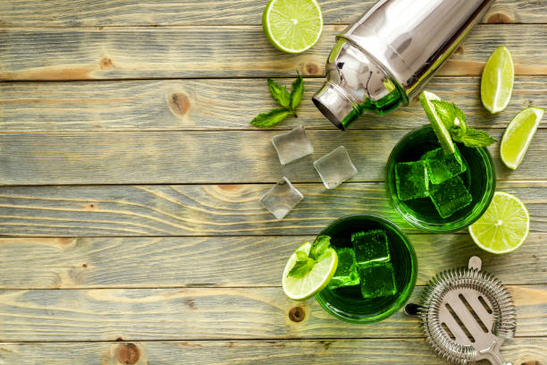 istock Green Mojito cocktail with bar utensils and ingredients. Top view 1297743429