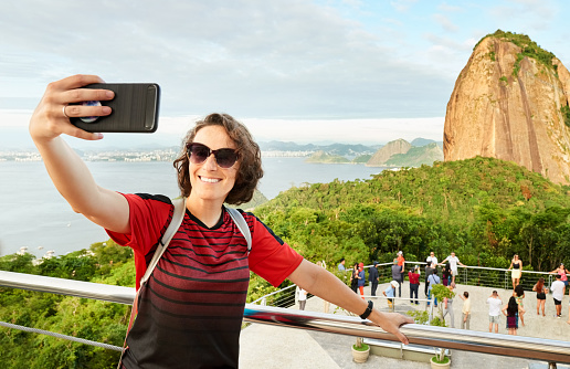 Female traveler taking selfies with Sugarloaf mountain in background
