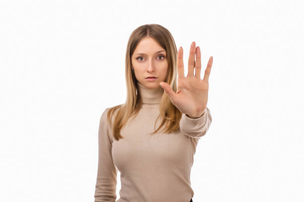 istock Serious blond girl keeps palm forward at camera, makes forbid sign, restricts or warns, extends arm in stop sign 1297744807