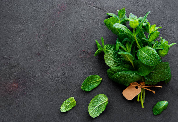 istock Fresh mint leaves herb on stone table. Top view 1297747562