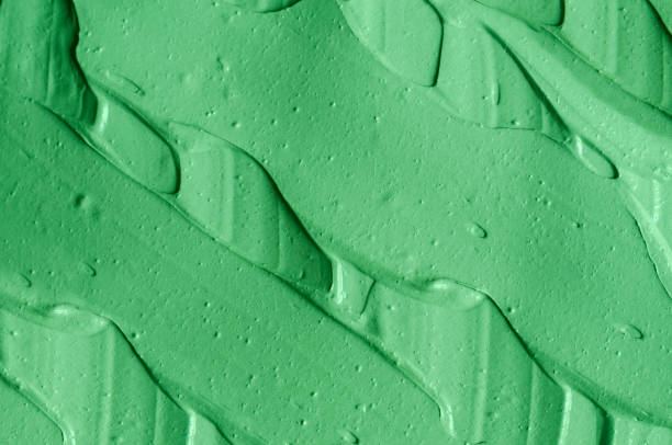 istock Green cosmetic clay (cucumber facial mask, avocado face cream, matcha body wrap) texture close up, selective focus. Abstract background with brush strokes. 1297750677