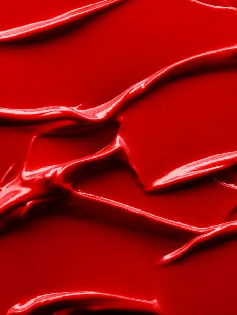 Cosmetic background of red smudged lipstick close up