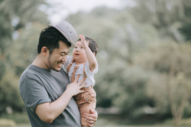 istock asian chinese father carrying his son at public park during weekend bonding playing with hat 1297752571