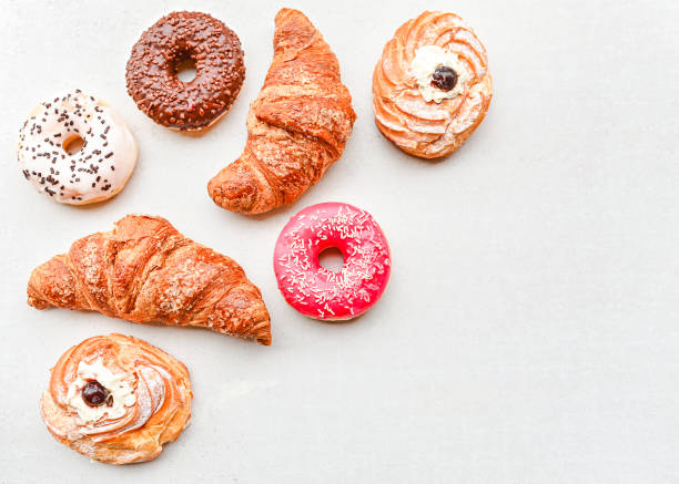 сладкий доброе утро концепции с ассорти свежей пекарни сладкий на белом фоне. круассаны, пончики, пирожные - croissant morning white breakfast стоковые фото и изображения
