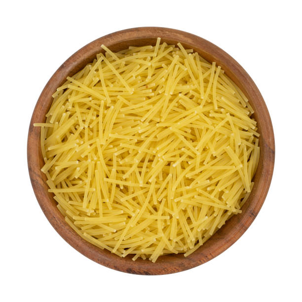 istock Uncooked vermicelli pasta in wooden bowl. Isolated on white background with clipping path 1297756676