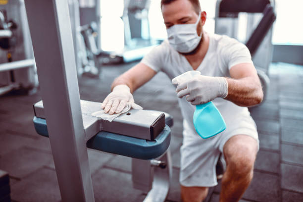 istock Gym Worker Taking Care To Sanitize Equipment 1297762044