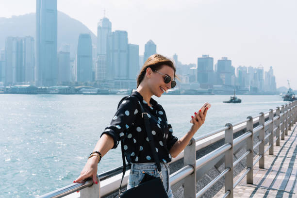 istock Smiling young blonde female traveler satisfied with 4G connection in roaming browsing web pages and social networks, happy hipster girl using smartphone app for navigating during journey in town 1297762081