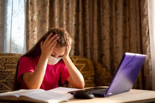 Bored girl tired of distance online learning at home because of Covid-19 pandemic Small schoolgirl wants to go to school, meet friends and go outside boring homework twelve stock pictures, royalty-free photos & images