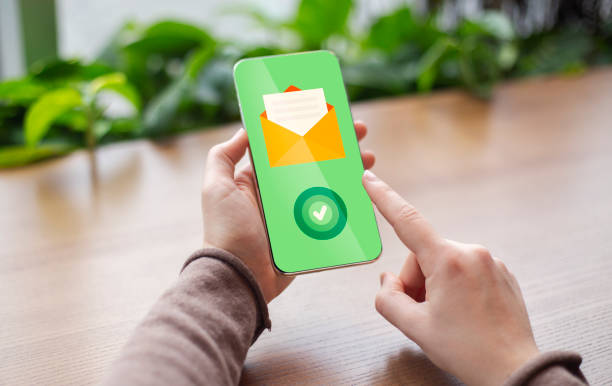 istock Email Communication. Woman Holding Smartphone With Opened Envelope Icon And Check Mark 1297763275