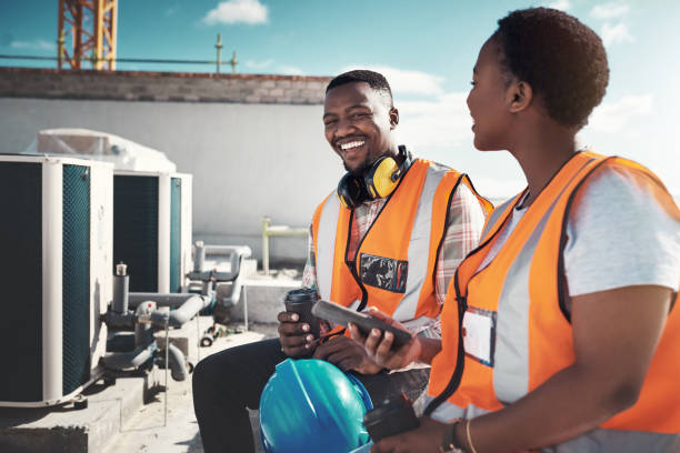 A recharge before they raise the roof Shot of a young man and woman having a coffee break at a construction site construction lunch break stock pictures, royalty-free photos & images