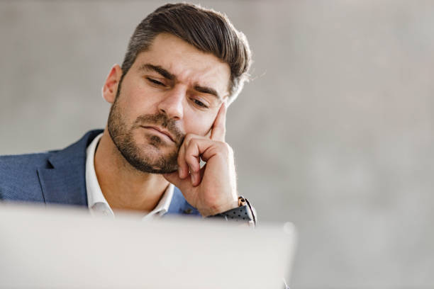 istock Thoughtful businessman reading an e-mail on laptop in the office. 1297763721