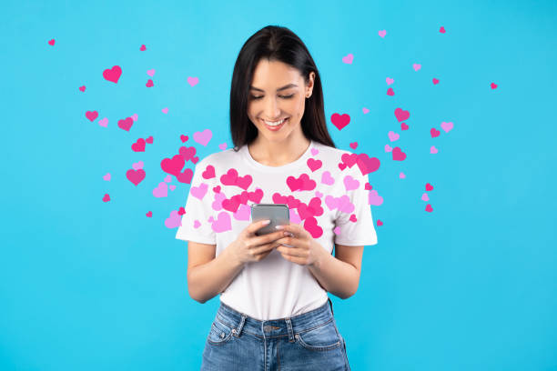 istock Woman sending love text message on cellphone, hearts flying away 1297763776