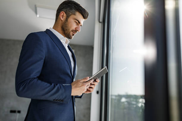 istock Male entrepreneur working on touchpad by the window. 1297763970