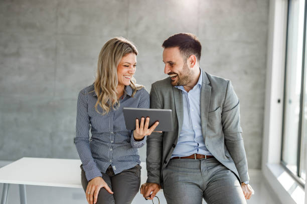 istock Happy business couple reading an e-mail on touchpad in the office. 1297764022