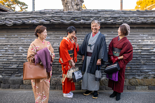 Japanese mid/mature friends in Kimono (traditional Japanese clothing) visiting Yanesen district in Tokyo. Eating lunch, walking around the town.