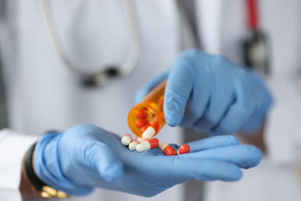 istock Doctor sprinkles the pills on gloved hand 1297764282