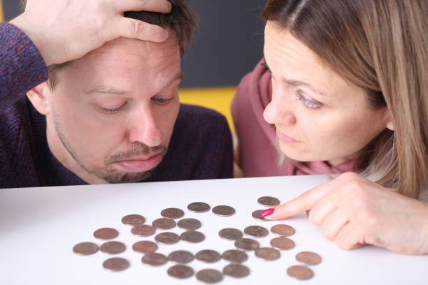 istock Man and a woman look upset at coins on table 1297764296