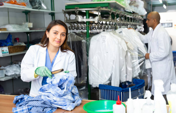 istock Focused woman drycleaner removing spots and stains 1297765180