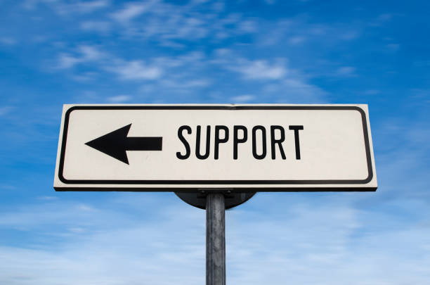 istock Support road sign, arrow on blue sky background. One way blank road sign with copy space. Arrow on a pole pointing in one direction. 1297765404