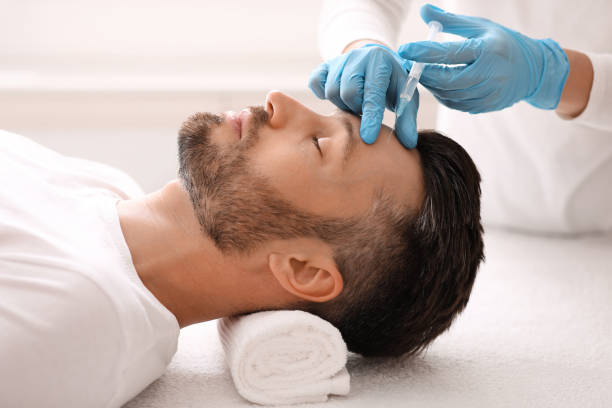 istock Plastic surgeon injecting hyaluronic acid in man forehead 1297765552