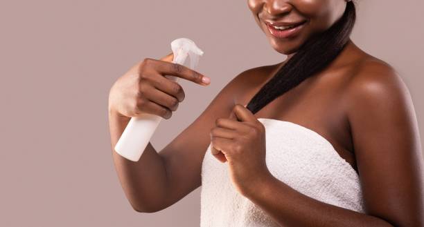 istock Split Ends. Young Black Lady Applying Hair Repair Treatment Spray After Bath 1297765964