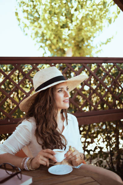 istock relaxed young female in white shirt sitting at table 1297766025