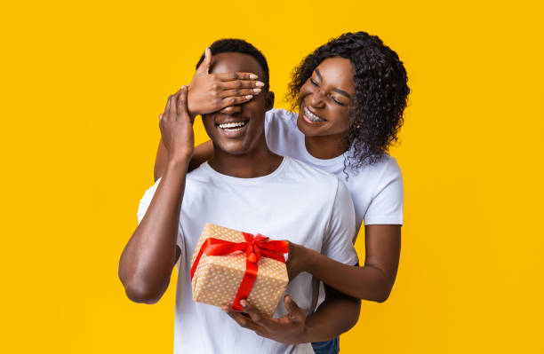 istock Happy black lady giving present to her boyfriend 1297766277