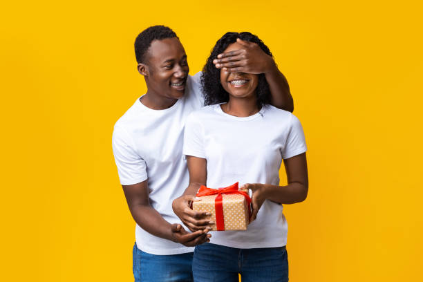 istock Happy young black guy giving present to his girlfriend 1297766348
