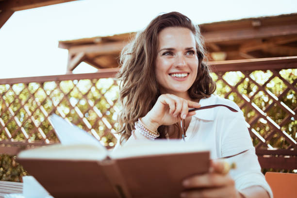 istock happy woman in white shirt with book 1297767425