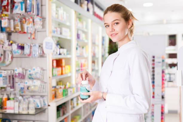 istock Female pharmacist offering help in choosing at counter in pharmacy 1297767658