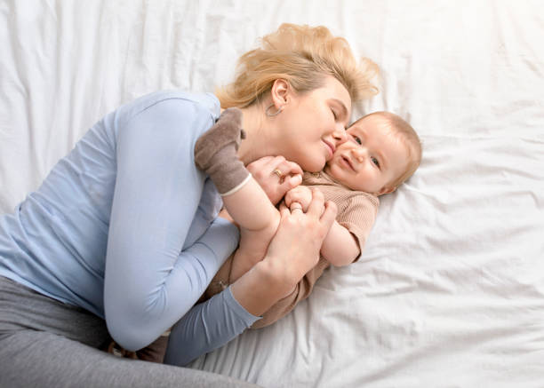 istock Loving mother caressing her baby boy on bed 1297768850