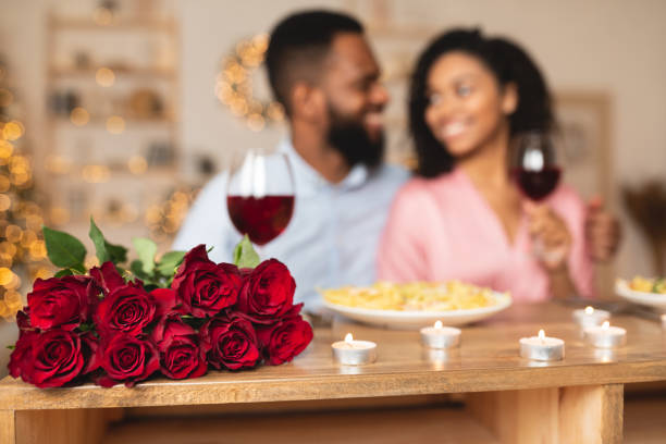 homme noir ayant le dîner avec la femme, se concentrent sur des roses - anniversary couple rose black photos et images de collection