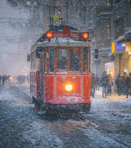 Winter and Red Tram in Istiklal Street, Beyoglu, Istanbul. Nostalgic Trams with light passing through Istiklal street in a snowy winter evening in Taksim, Beyoğlu, Istanbul, Turkey. overhead cable car photos stock pictures, royalty-free photos & images