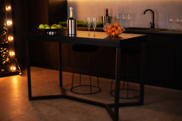 istock Modern kitchen interior in a loft style in dark colors. Stylish modern kitchen area with an island. Champagne bottle in bucket with ice and glasses of Champagne on kitchen island. celebration concept 1297773395