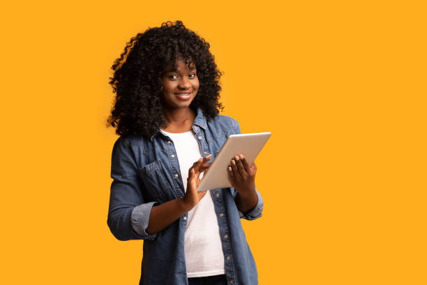 istock Cheerful beautiful black woman using digital tablet 1297773613