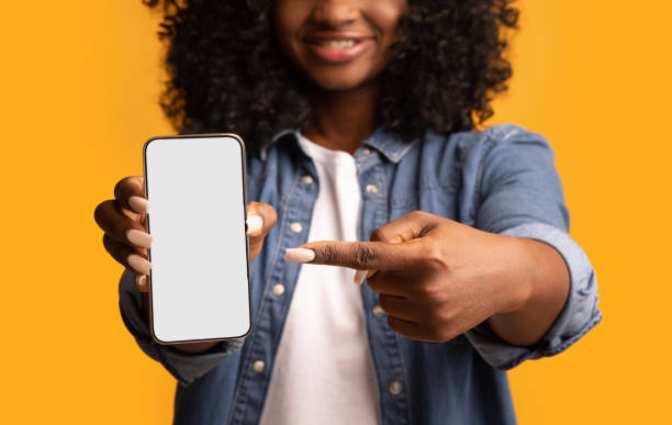 istock Black woman pointing at smartphone with empty screen 1297773724