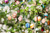 many colorful painted easter eggs on apple tree as easter decoration