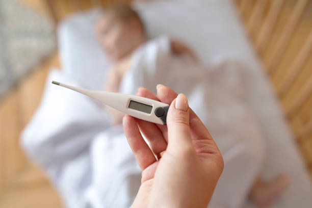 istock Electronic thermometer with empty display in mother hand 1297776897