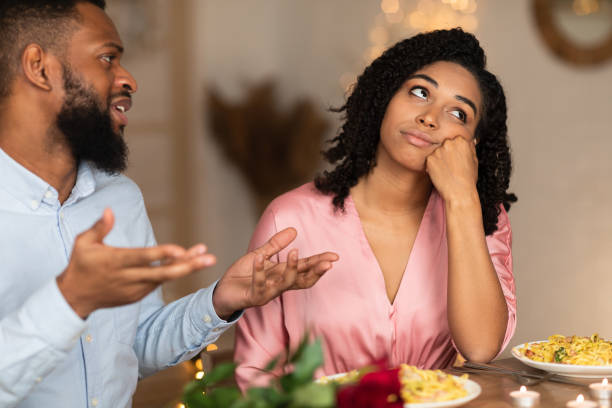 Unhappy Sad Black Couple Arguing During Dinner Bored unhappy black girlfriend listening to African American boyfriend in cafe, bad first impression and date concept, young couple sitting at table, talking, having problem in relationships black couple arguing stock pictures, royalty-free photos & images